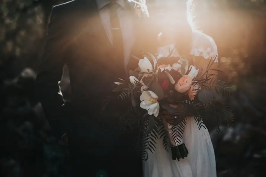 Pengantin berpelukan dengan buket, disinari cahaya matahari sore
